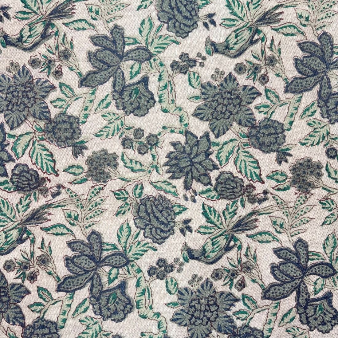 Floral pattern with dark blue and green leaves on a light background