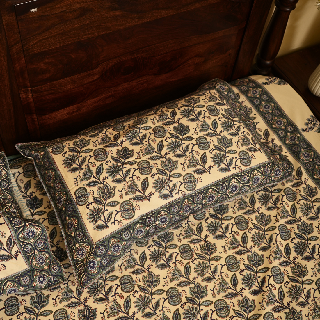 Set of floral-patterned Pllow in front of a wooden piece of furniture.