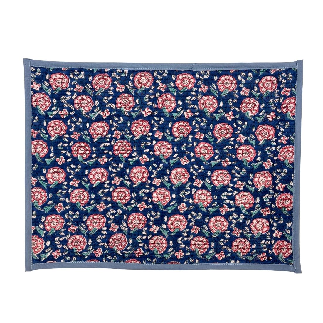 Floral patterned placemat with pink flowers on a blue background
