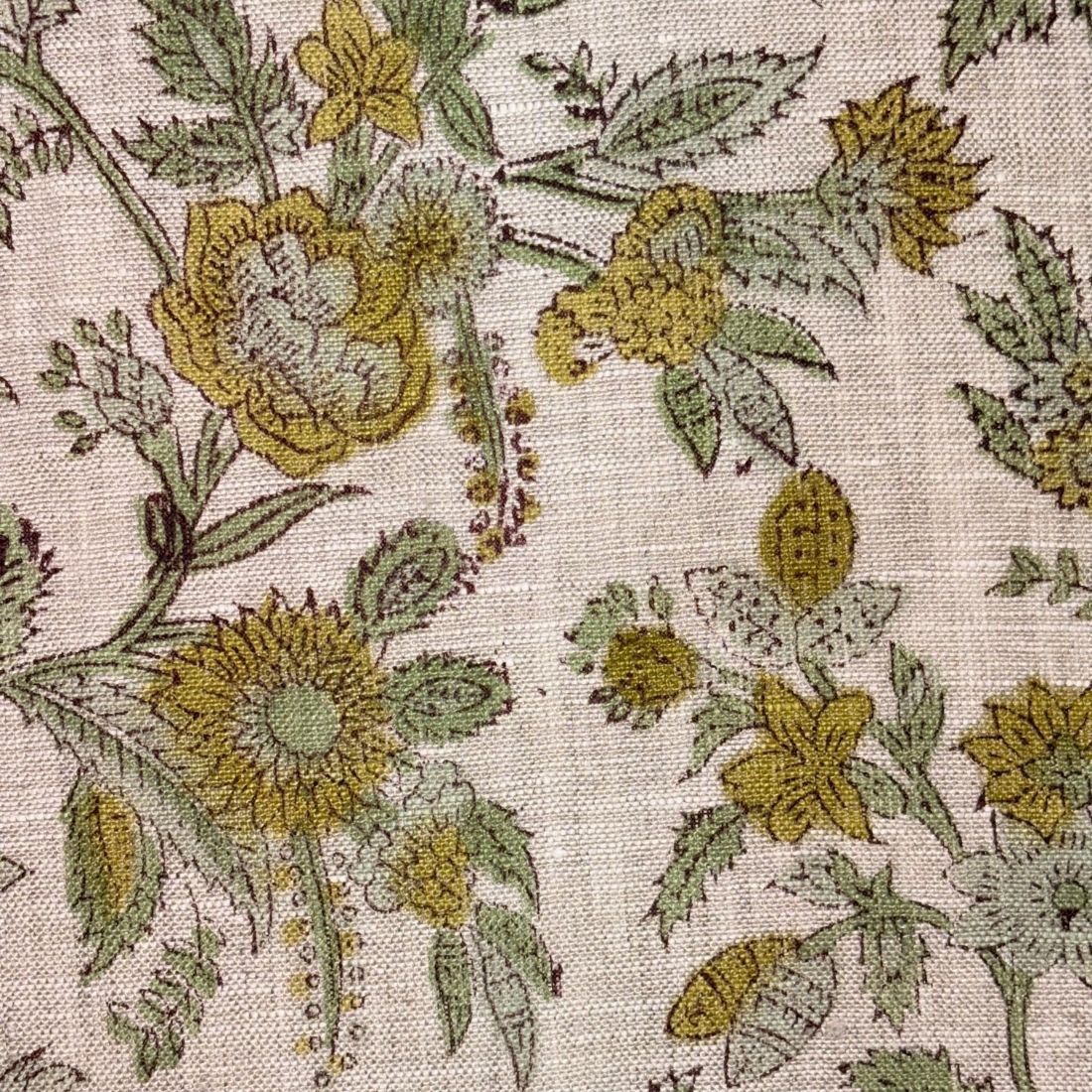 Close-up of floral fabric pattern with yellow and green flowers on a grey background