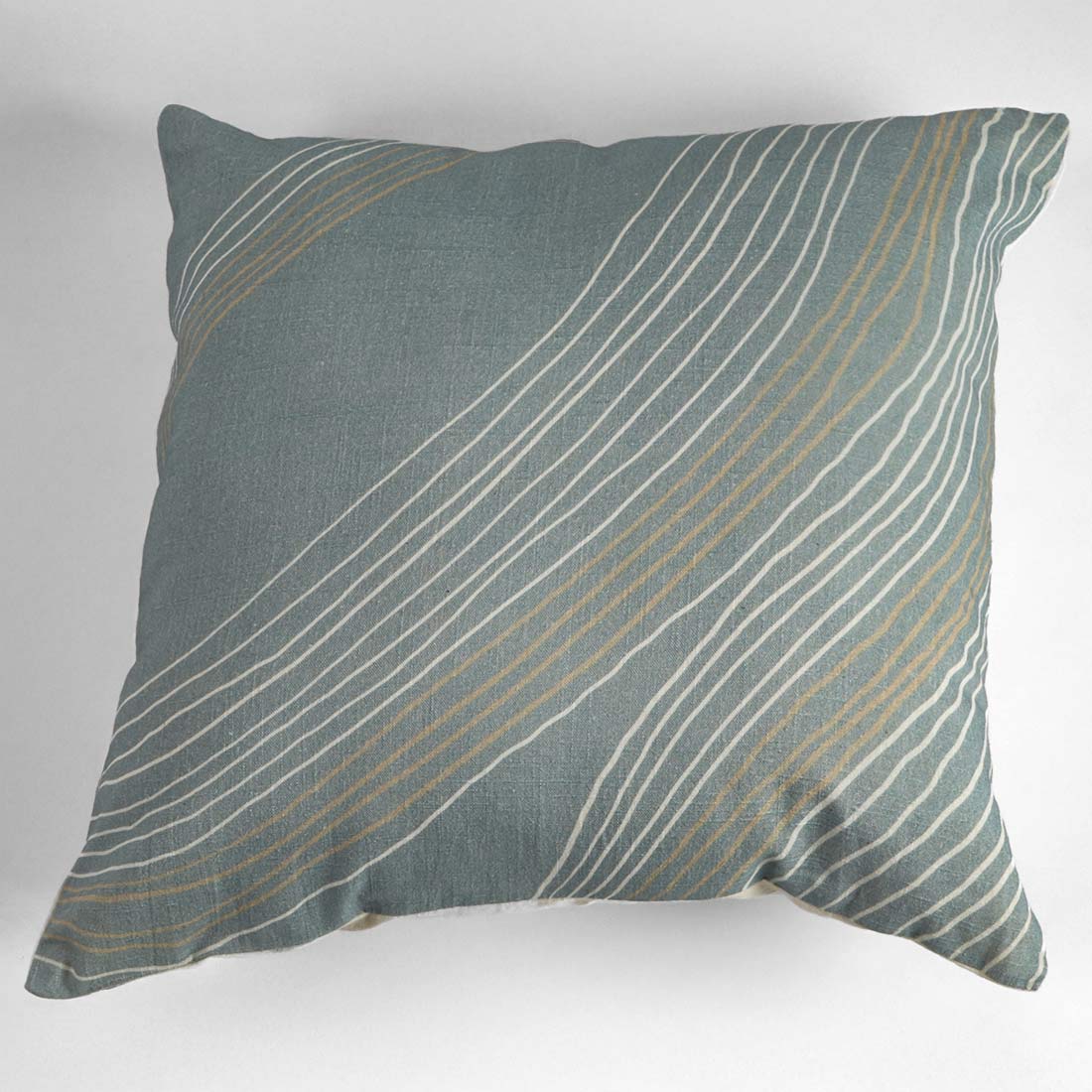 Decorative pillow with wavy line pattern on a plain background