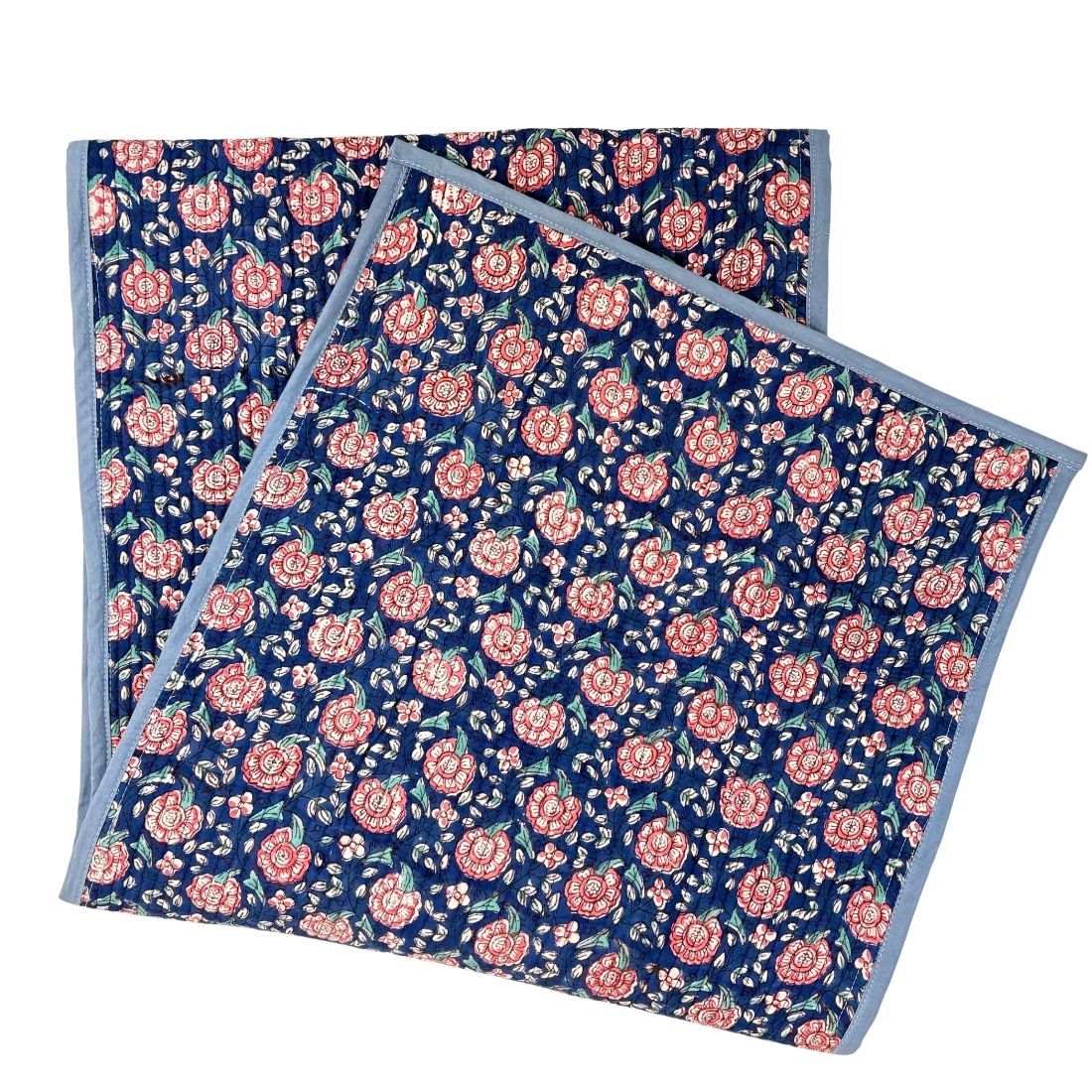 Floral patterned table runner with pink flowers on a blue background