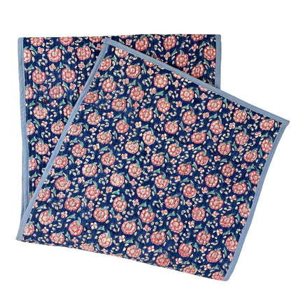 Floral patterned table runner with pink flowers on a blue background