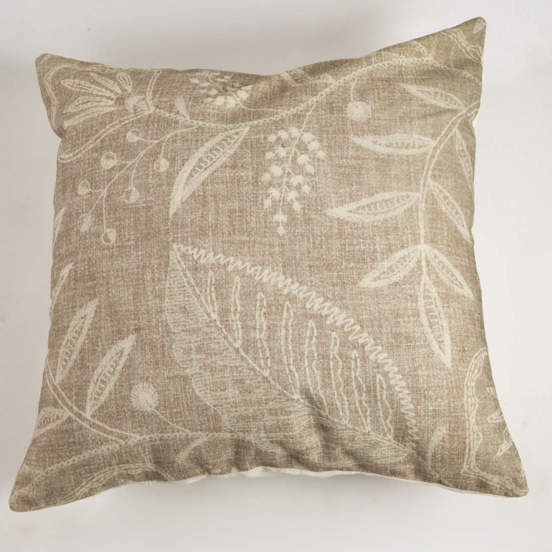 Decorative pillow with leaf pattern on a plain background