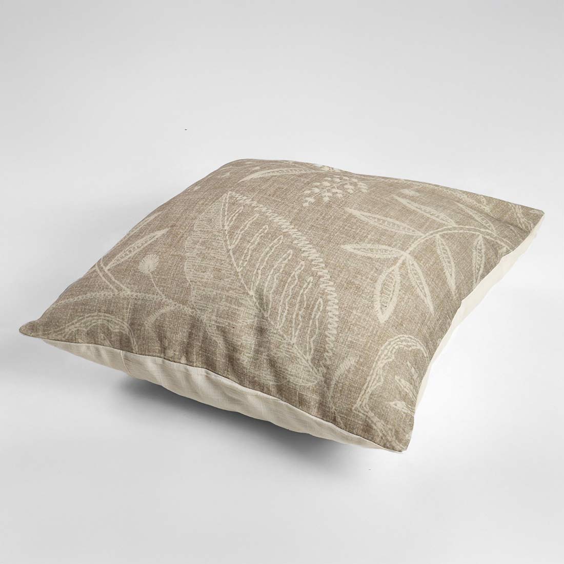 grey pillow with leaf pattern on a light gray background