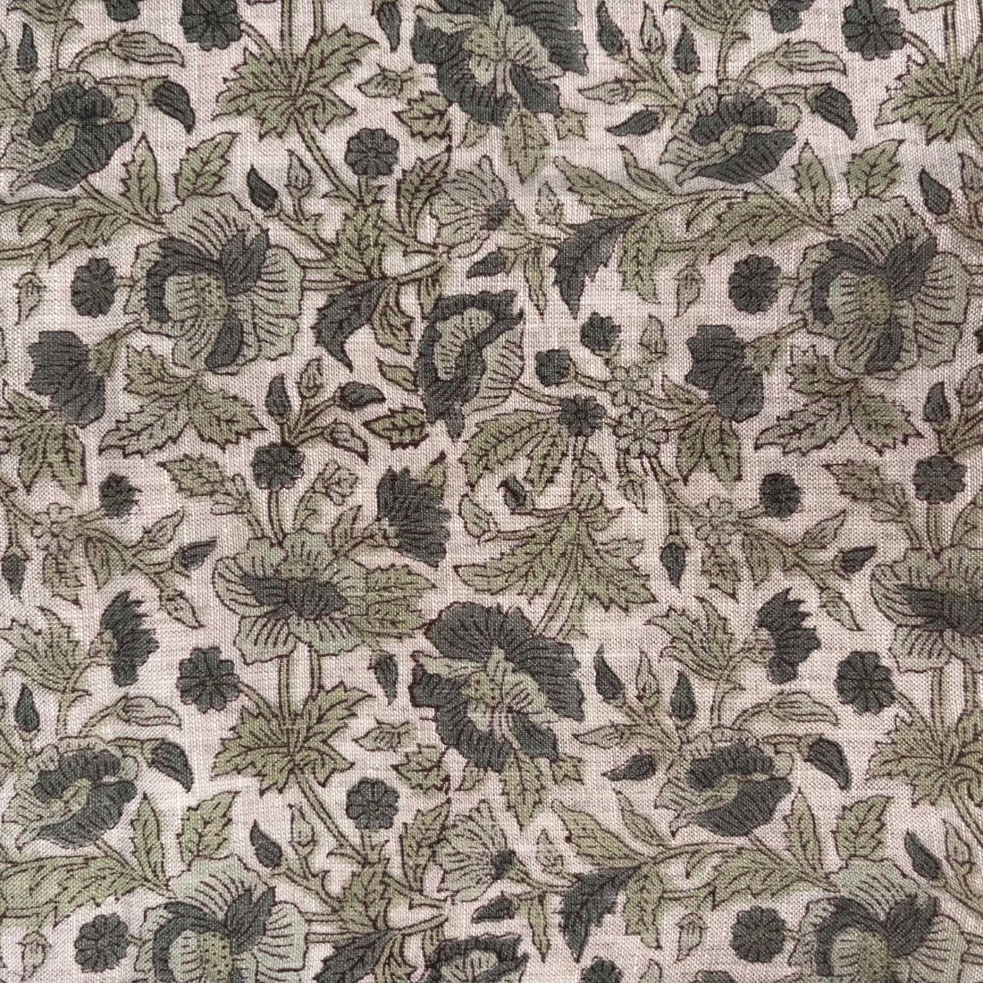 Floral patterned fabric with green and black flowers on a beige background
