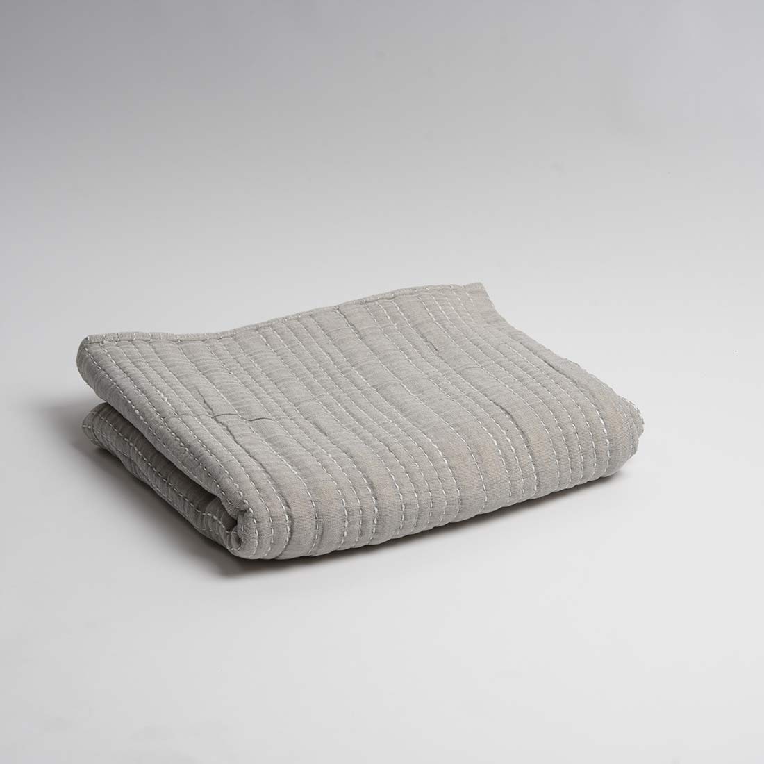 Folded gray throw on a light gray background