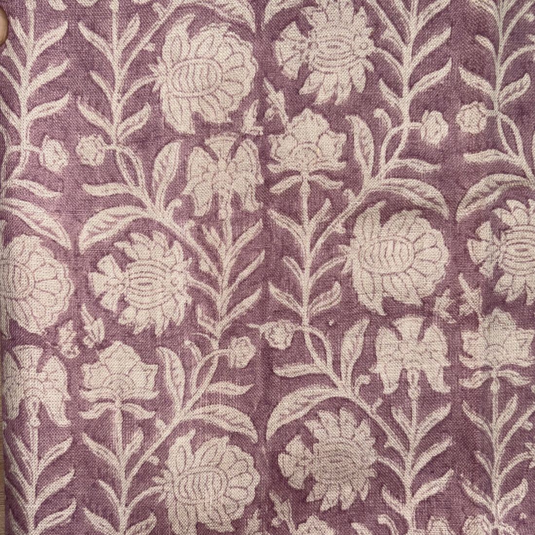Floral patterned fabric with grey flowers on a purple background