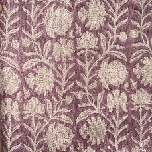 Floral patterned fabric with grey flowers on a purple background