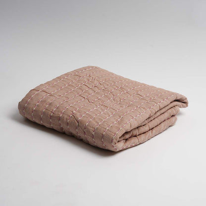 Folded beige throw on a light gray background