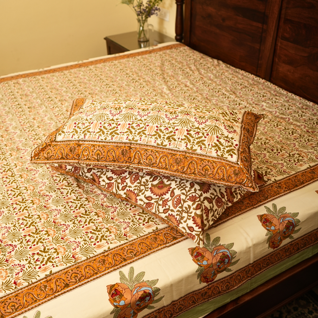 Decorative bedspread with intricate patterns on a bed in a bedroom setting.