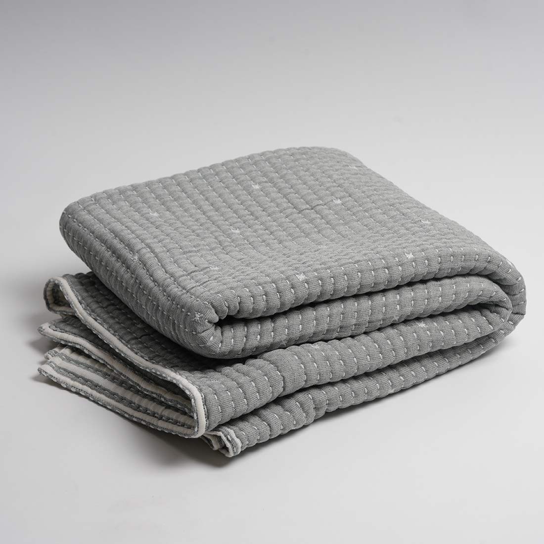 Folded gray textured throw on a light gray background
