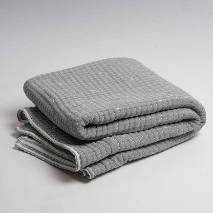 Folded gray textured throw on a light gray background