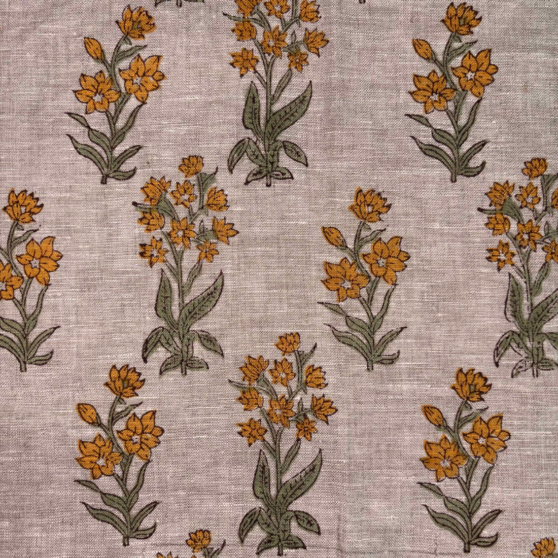Pattern of orange flowers with green leaves on a textured grey background