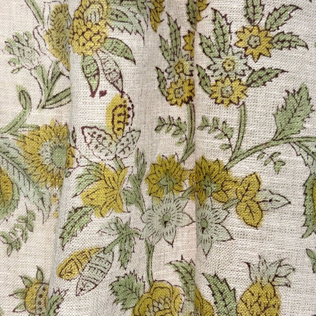 Close-up of floral fabric pattern with yellow and green flowers on a grey background