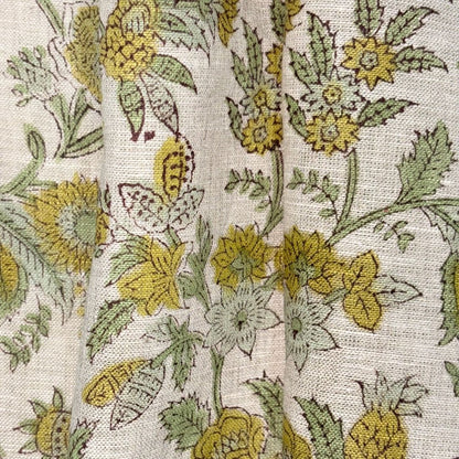 Close-up of floral fabric pattern with yellow and green flowers on a grey background