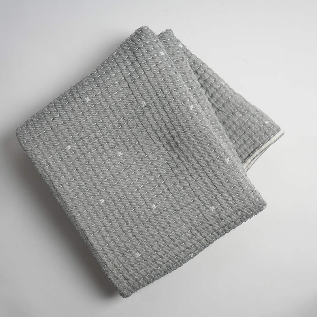 Folded gray textured throw on a light gray background