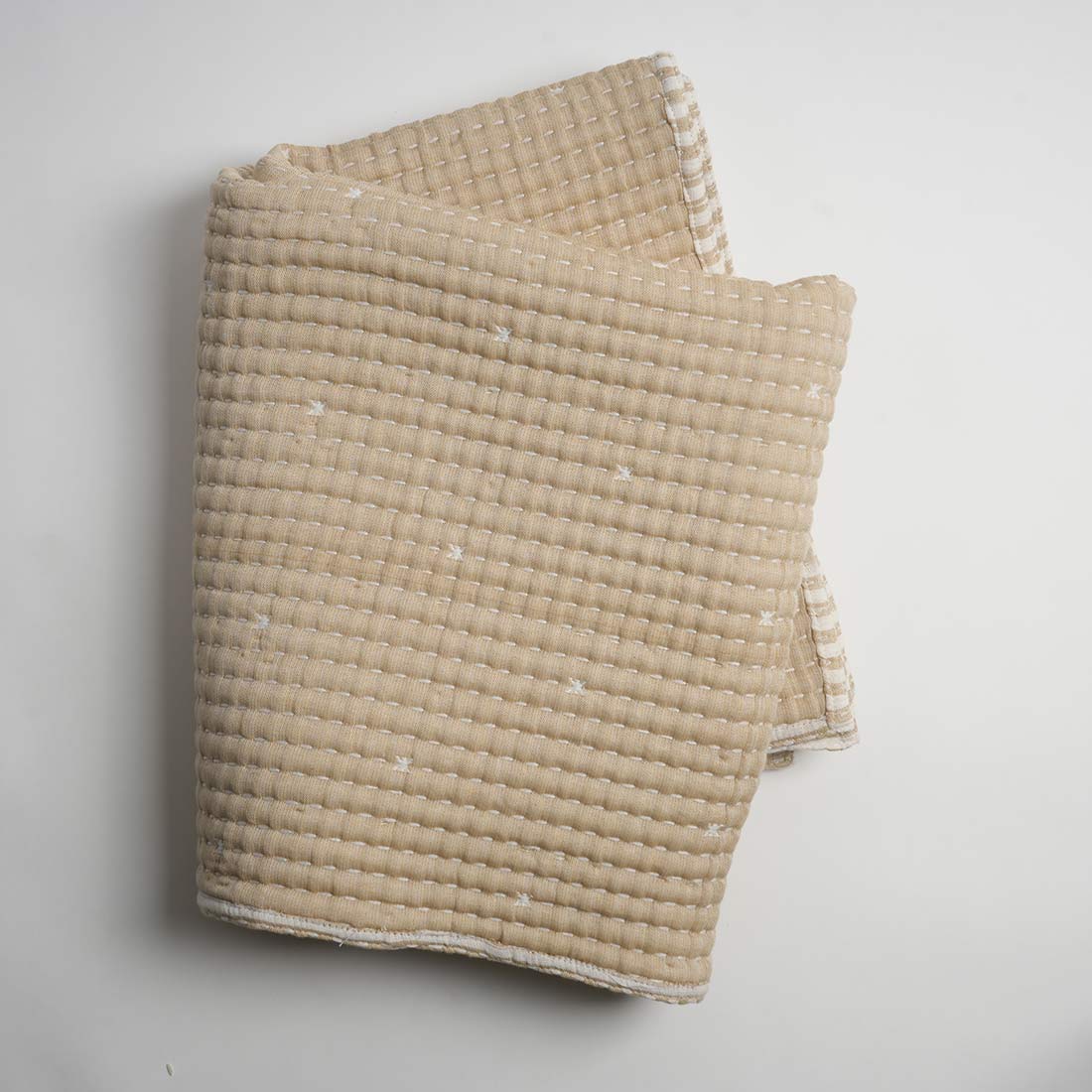 Beige textured blanket on a light gray background