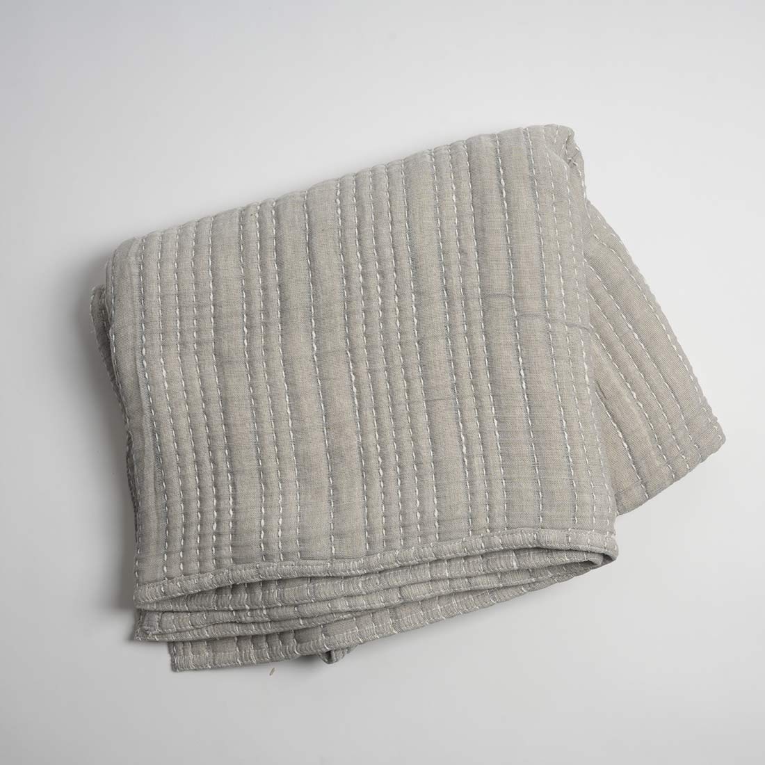 Folded gray textured blanket on a white background