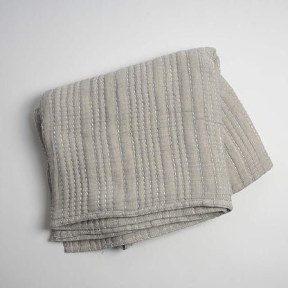 Folded gray textured blanket on a white background