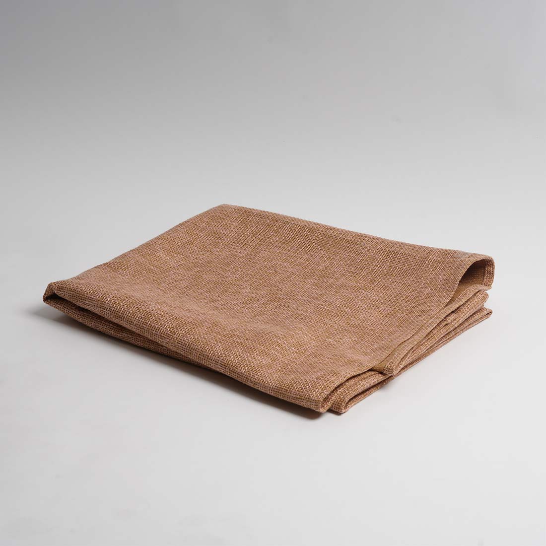 Folded brown throw on a light gray background