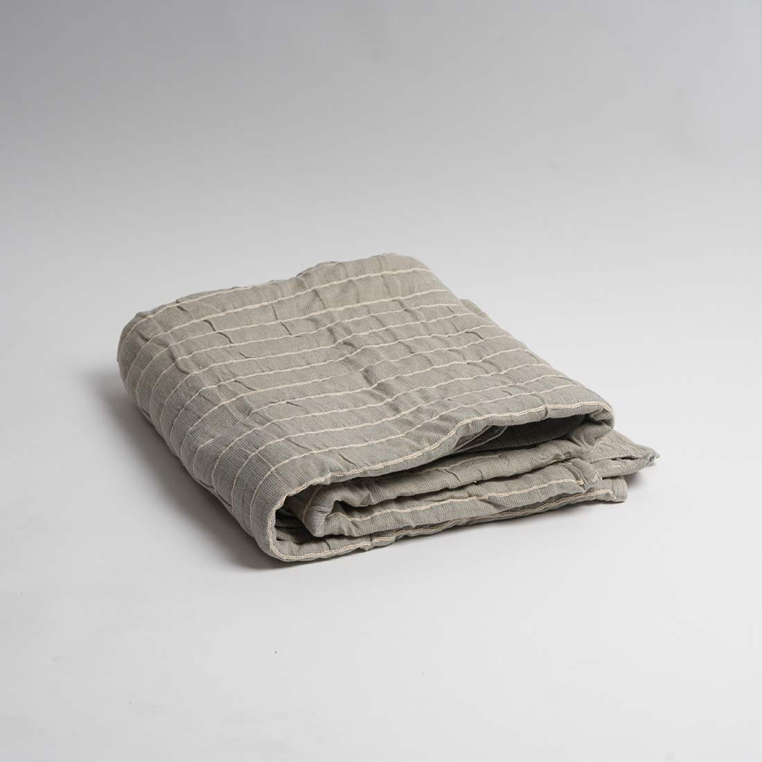Folded gray checkered blanket on a light gray background