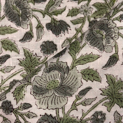 Close-up of floral fabric pattern with green flowers and leaves on a grey background