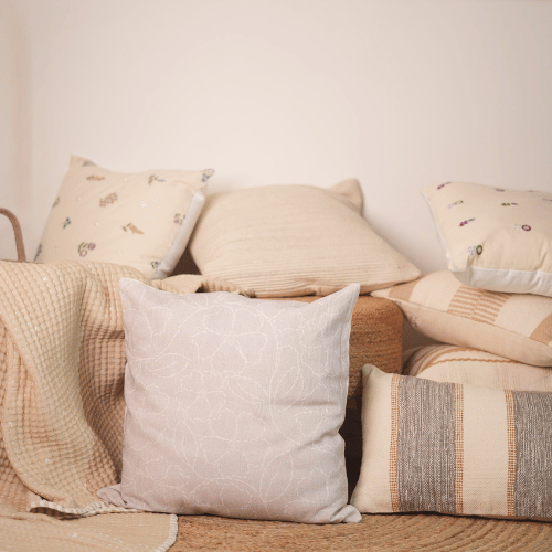 Collection of decorative pillows on a sofa with a neutral color palette.