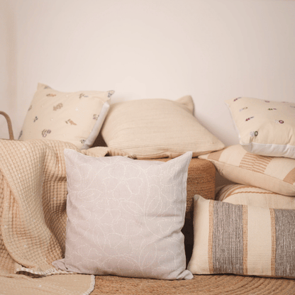 Collection of decorative pillows on a sofa with a neutral color palette.