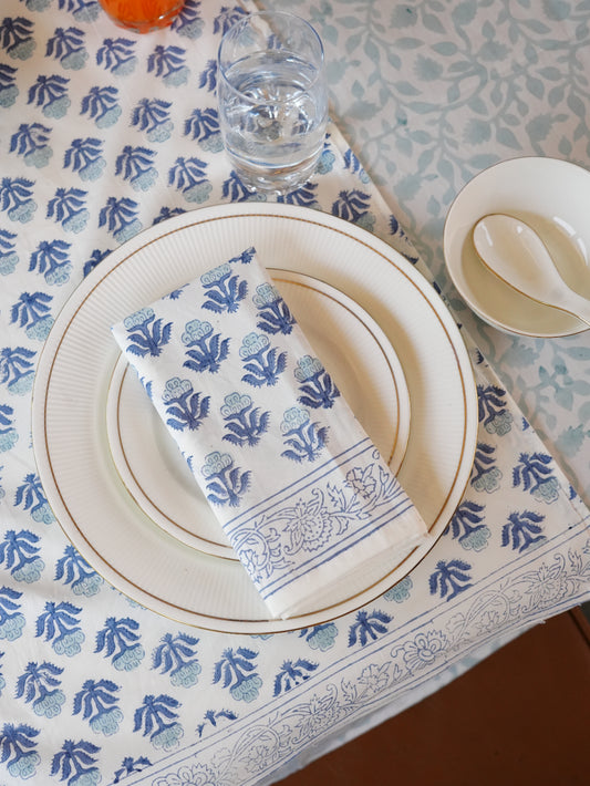Table setting with blue and white patterned tablecloth, plates, and napkin.