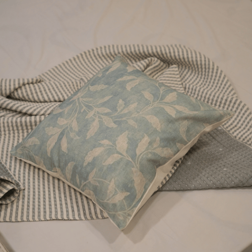 Decorative pillow with leaf pattern on a textured surface
