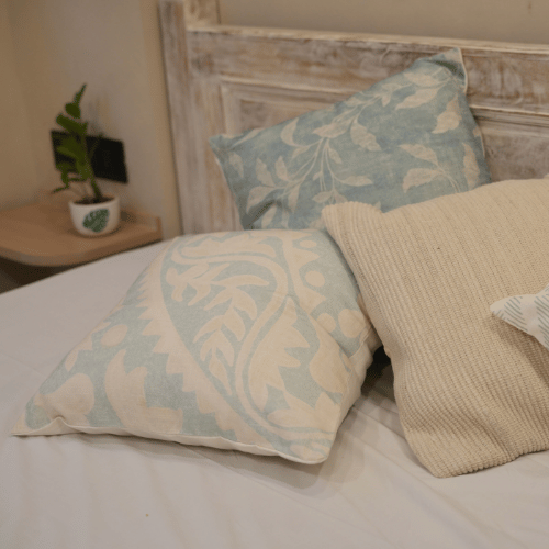Decorative pillows on a bed with a rustic headboard