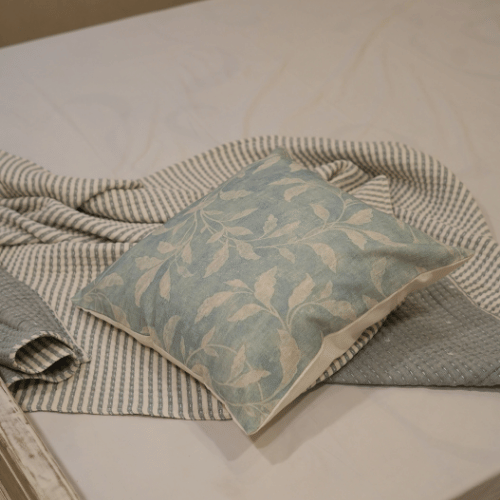 Decorative pillow with leaf pattern on a textured surface