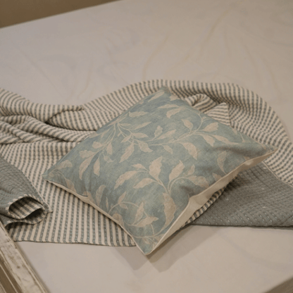 Decorative pillow with leaf pattern on a textured surface