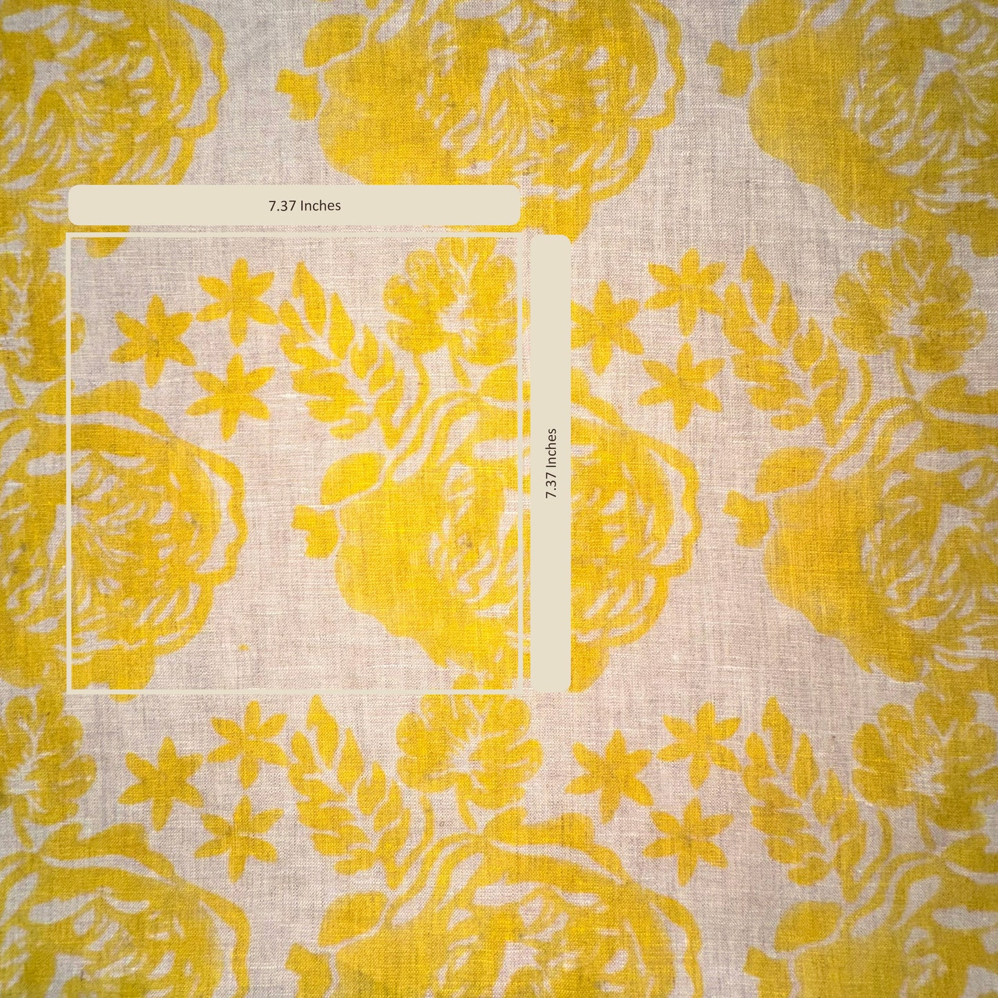 Yellow floral patterned fabric with a ruler for scale on a light background