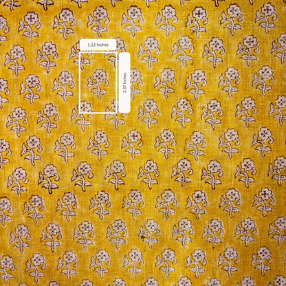 Yellow fabric with small floral pattern and a ruler for scale