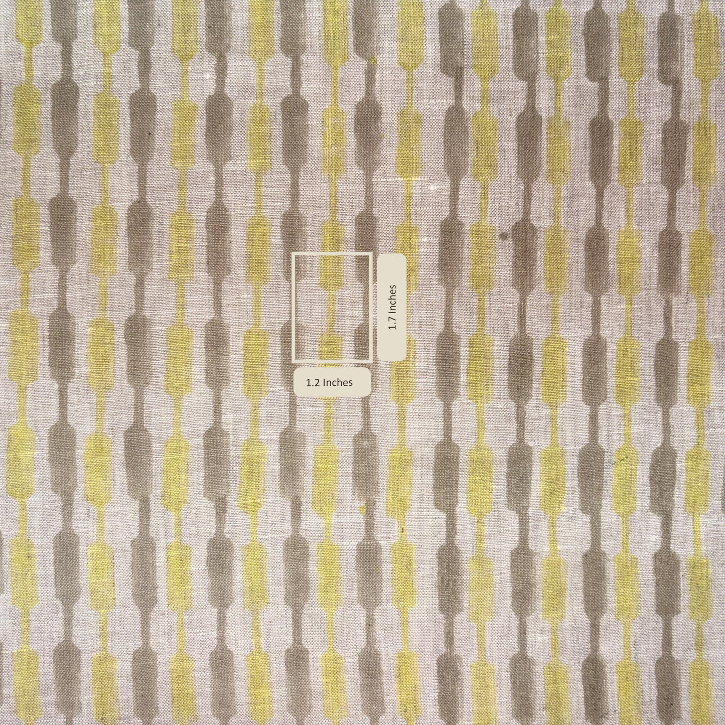 Fabric swatch with a geometric pattern in brown and yellow on a gray background