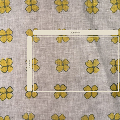 Fabric with yellow flower pattern and a ruler for scale on a gray background