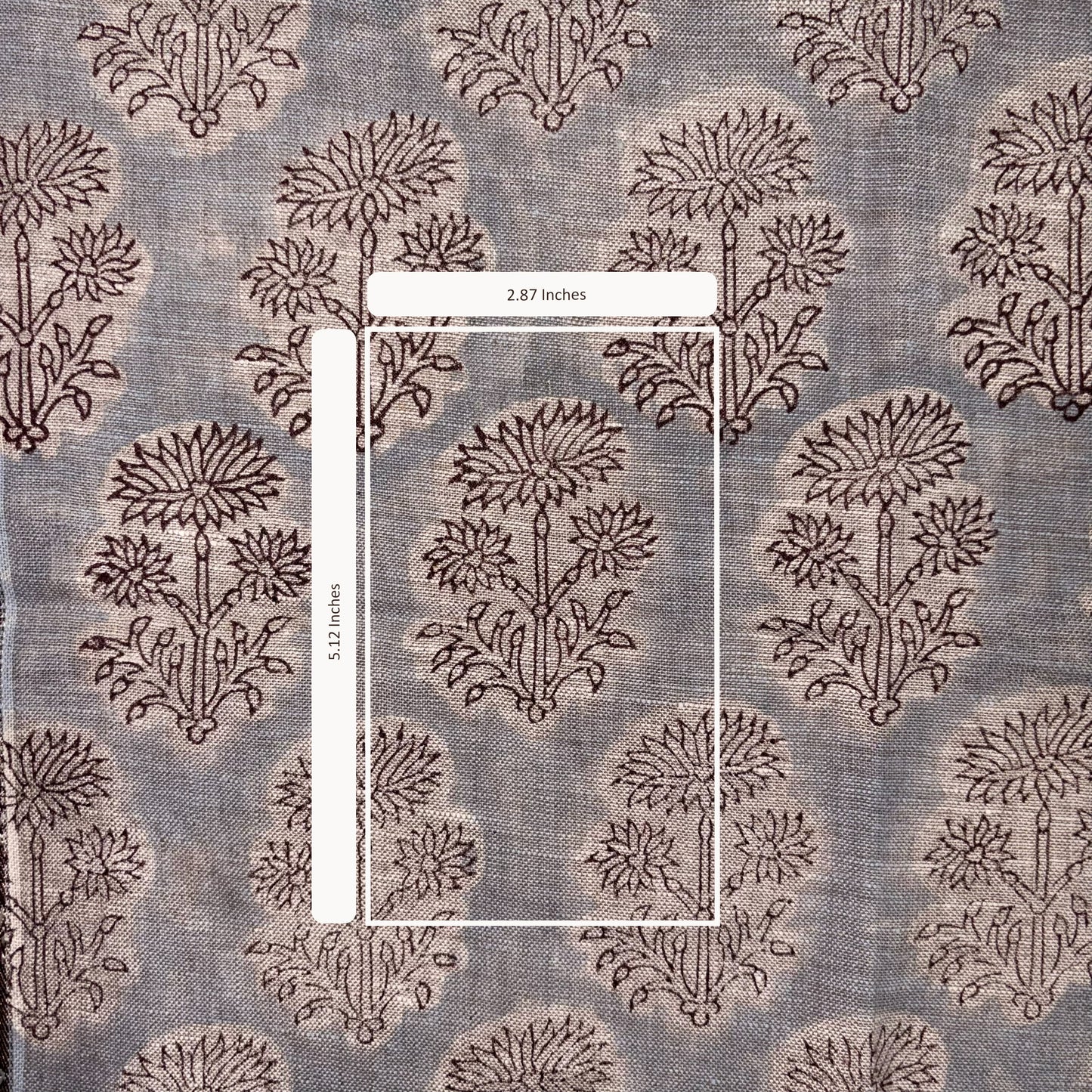 Textile with floral pattern and measurement label on a gray background