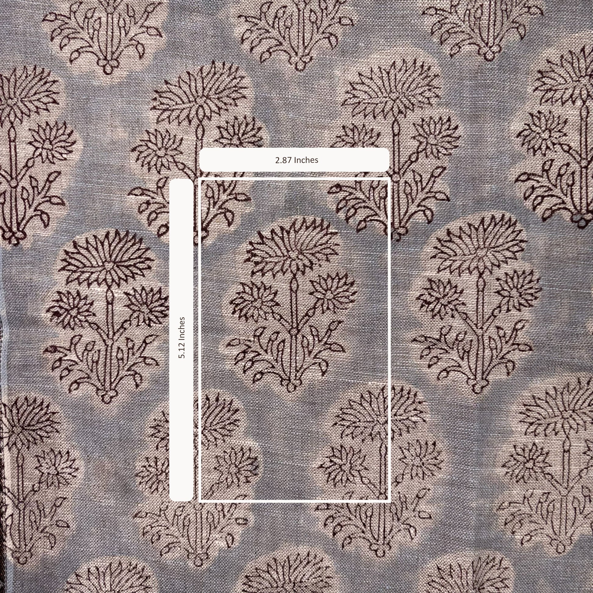 Textile with floral pattern and measurement label on a gray background