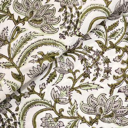 Close-up of a floral and leaf patterned fabric in green on a white background