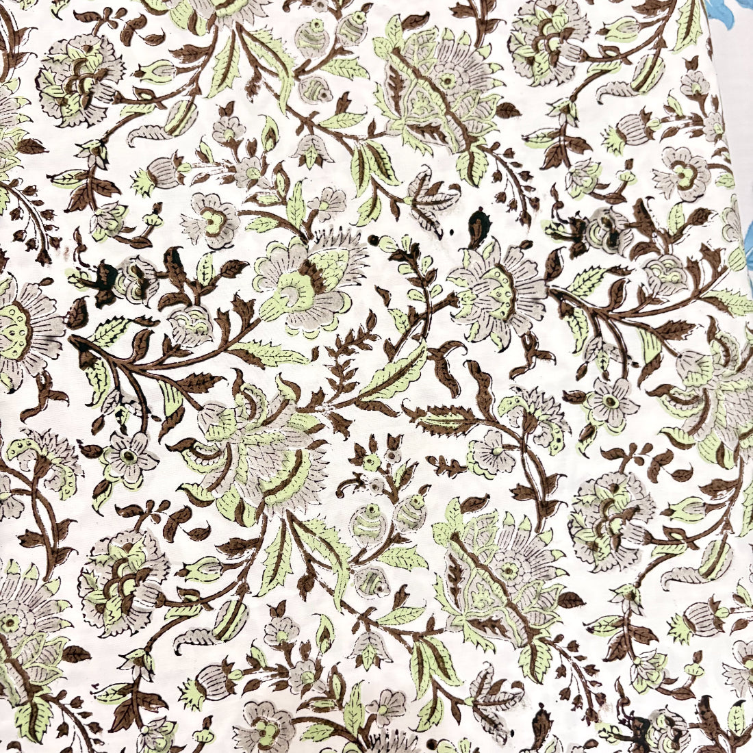 Floral patterned fabric in green and brown on a white background