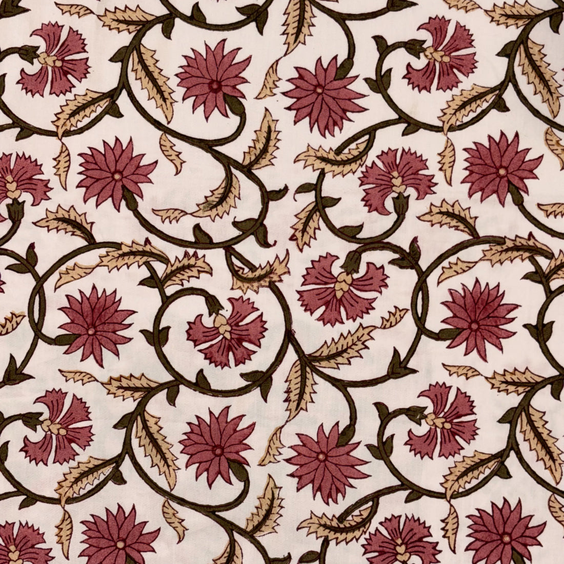 A close-up of a fabric pattern featuring dark brown scrolling vines and burgundy flowers on a warm cream background.