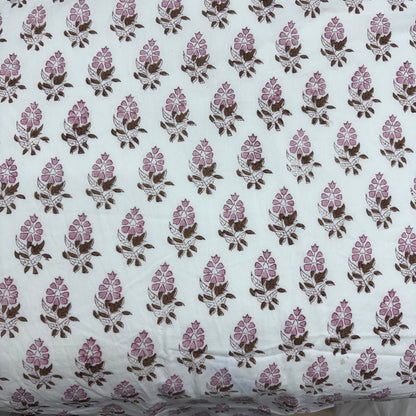 White cotton fabric with a repeating block-printed floral pattern in pink and brown.
