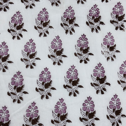 White fabric with a repeating block-print floral pattern in purple and dark brown.