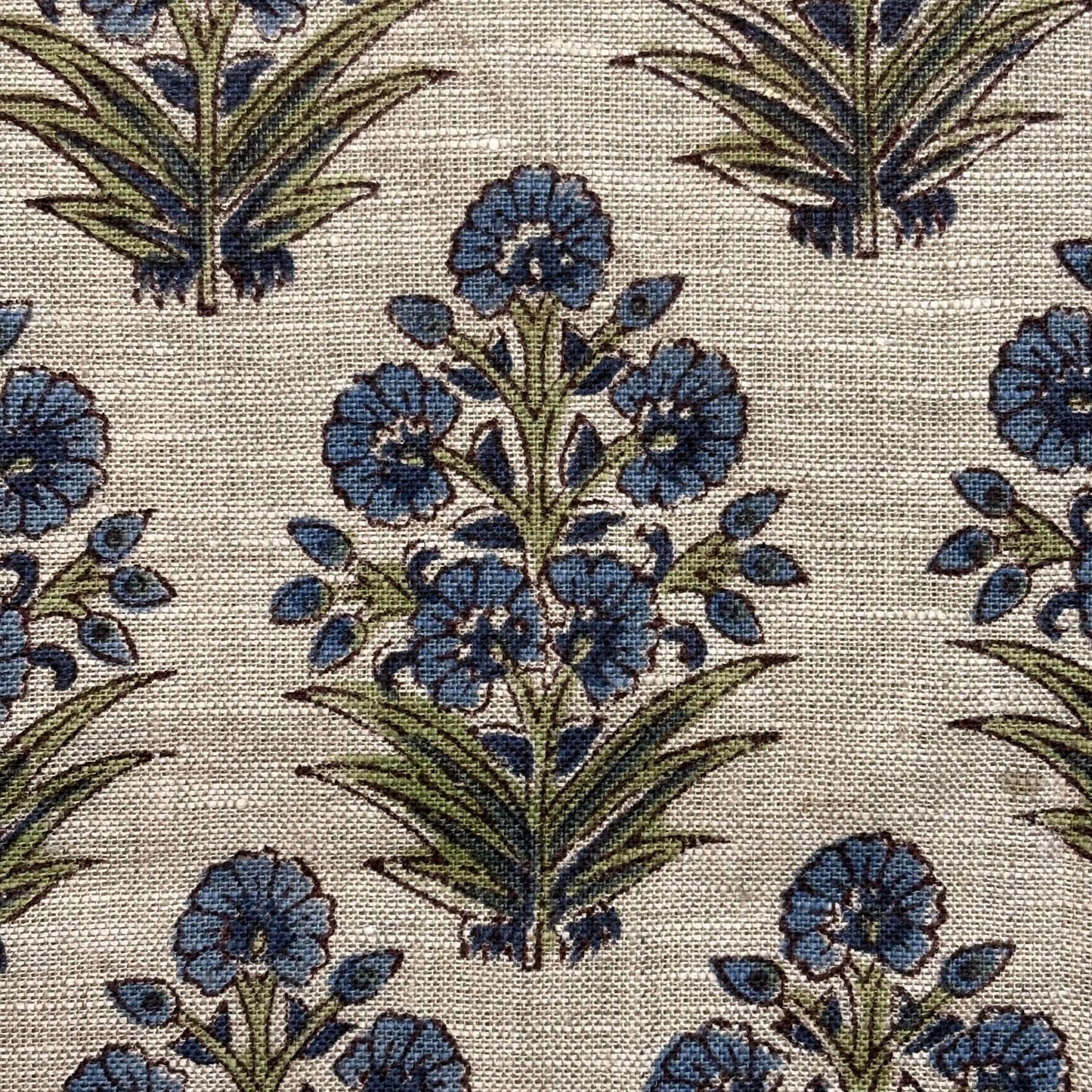 Patterned fabric with blue flowers and green leaves on a grey background