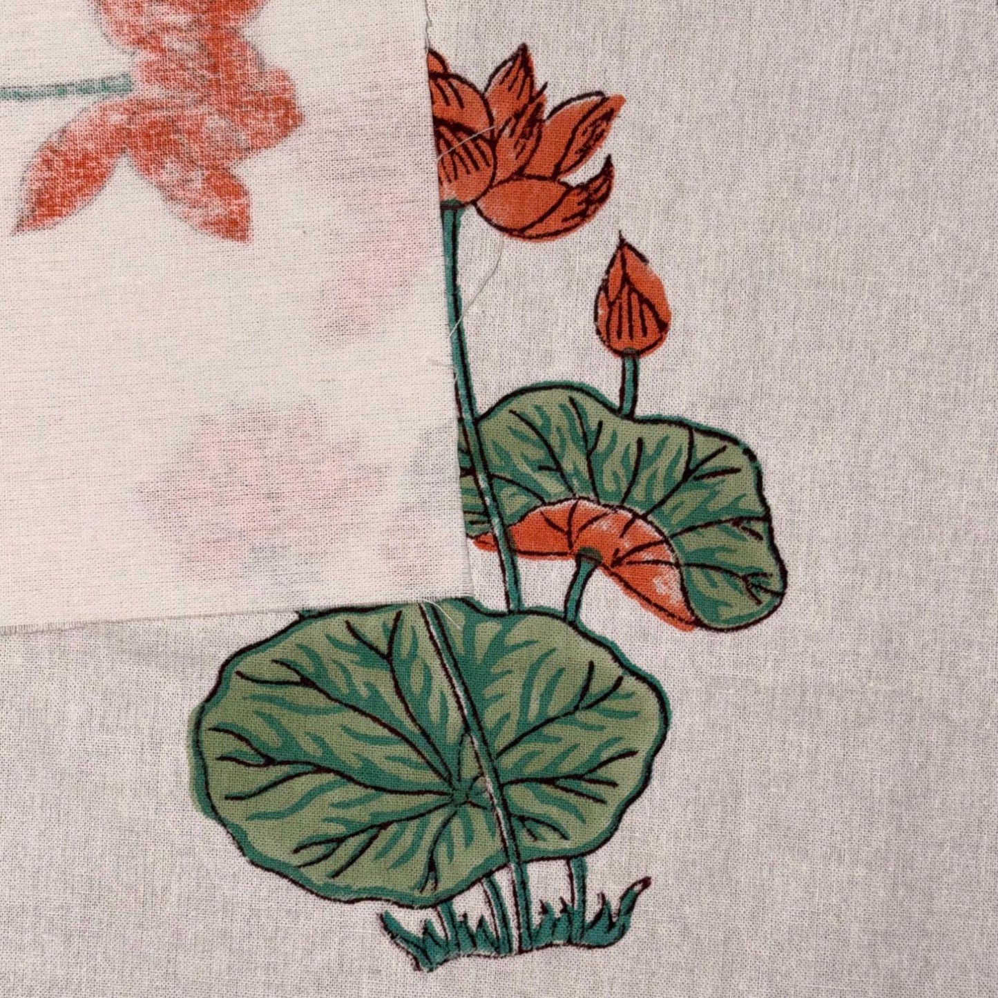 Embroidered design of red flowers and green leaves on a textured fabric background