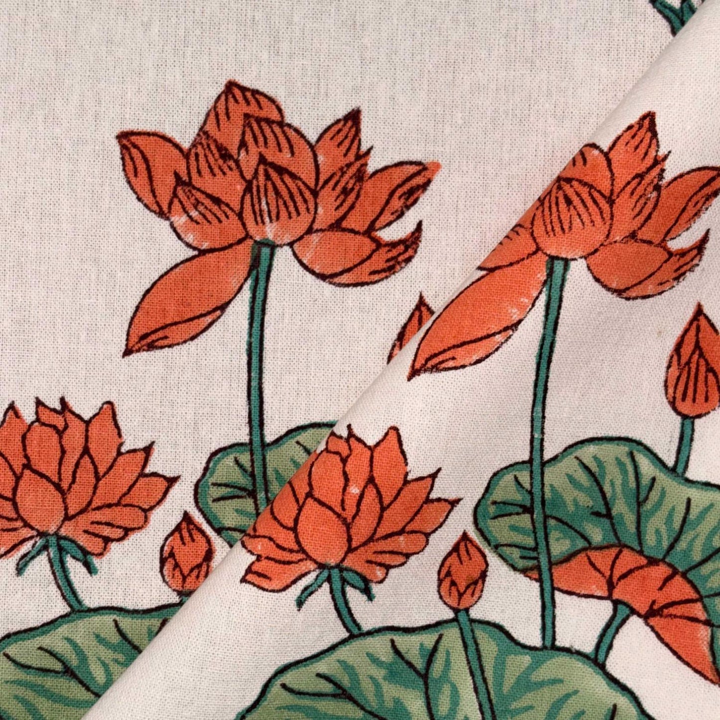 Close-up of fabric with red lotus flowers and green leaves on a white background