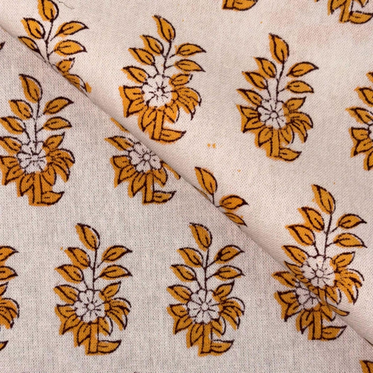 Close-up of fabric with yellow floral patterns on a beige background