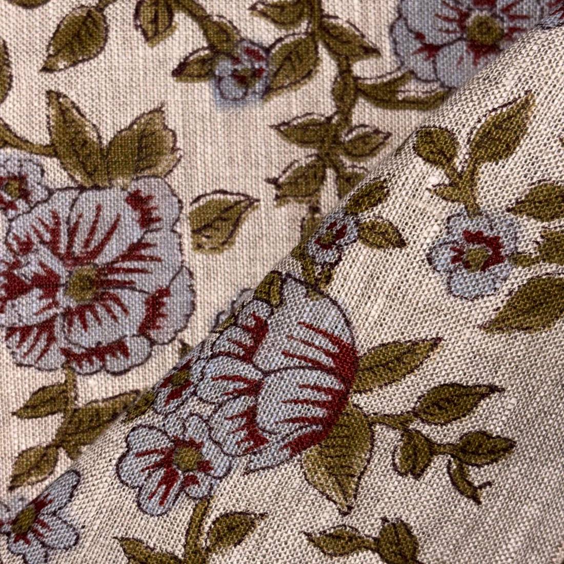 Close-up of floral fabric pattern with red and brown flowers on a beige background